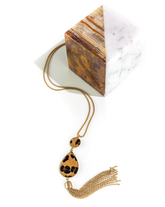 Necklace with leopard print pendant and tassel on a marble surface