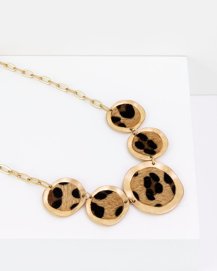 Gold necklace with circular pendants on a white background