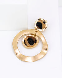 Gold circular earring on a white background with leopard faux fur