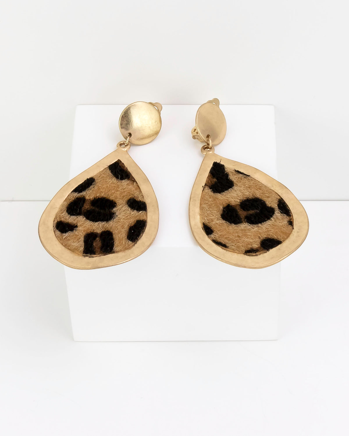 Gold teardrop earrings with leopard faux fur print on a white background
