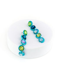 Multicolored gemstone earrings on a white plate