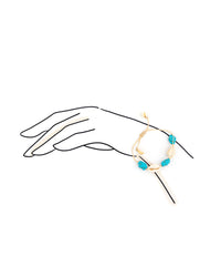 Bracelet with blue beads on a hand outline against a white background