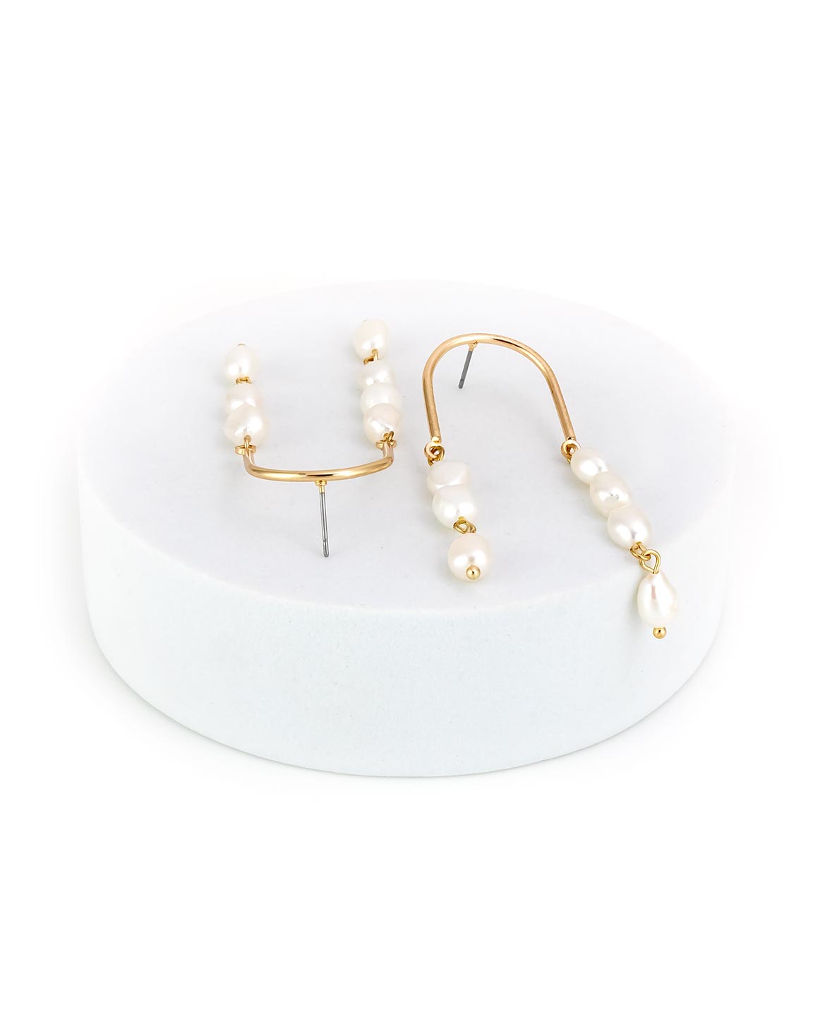 Pearl earrings with in gold-tone on a white stand