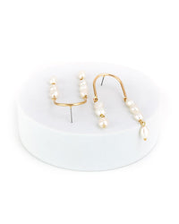 Pearl earrings with in gold-tone on a white stand