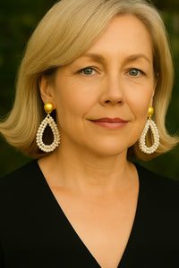 Woman wearing pearl earrings with a blurred green background