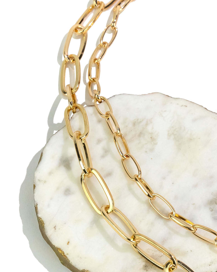 Gold chain necklace on a white shell
