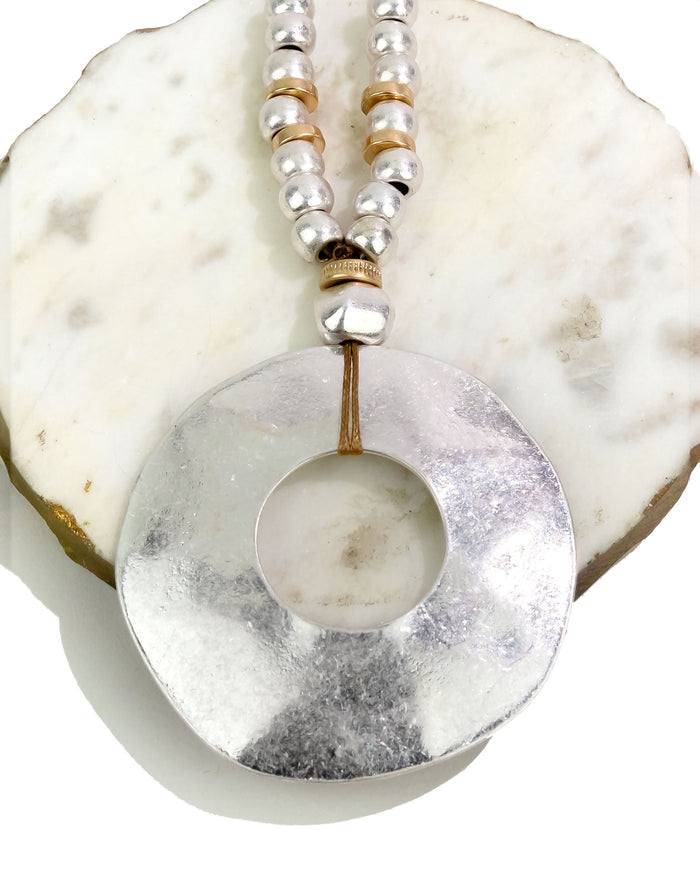 Necklace with a large silver pendant on a shell background
