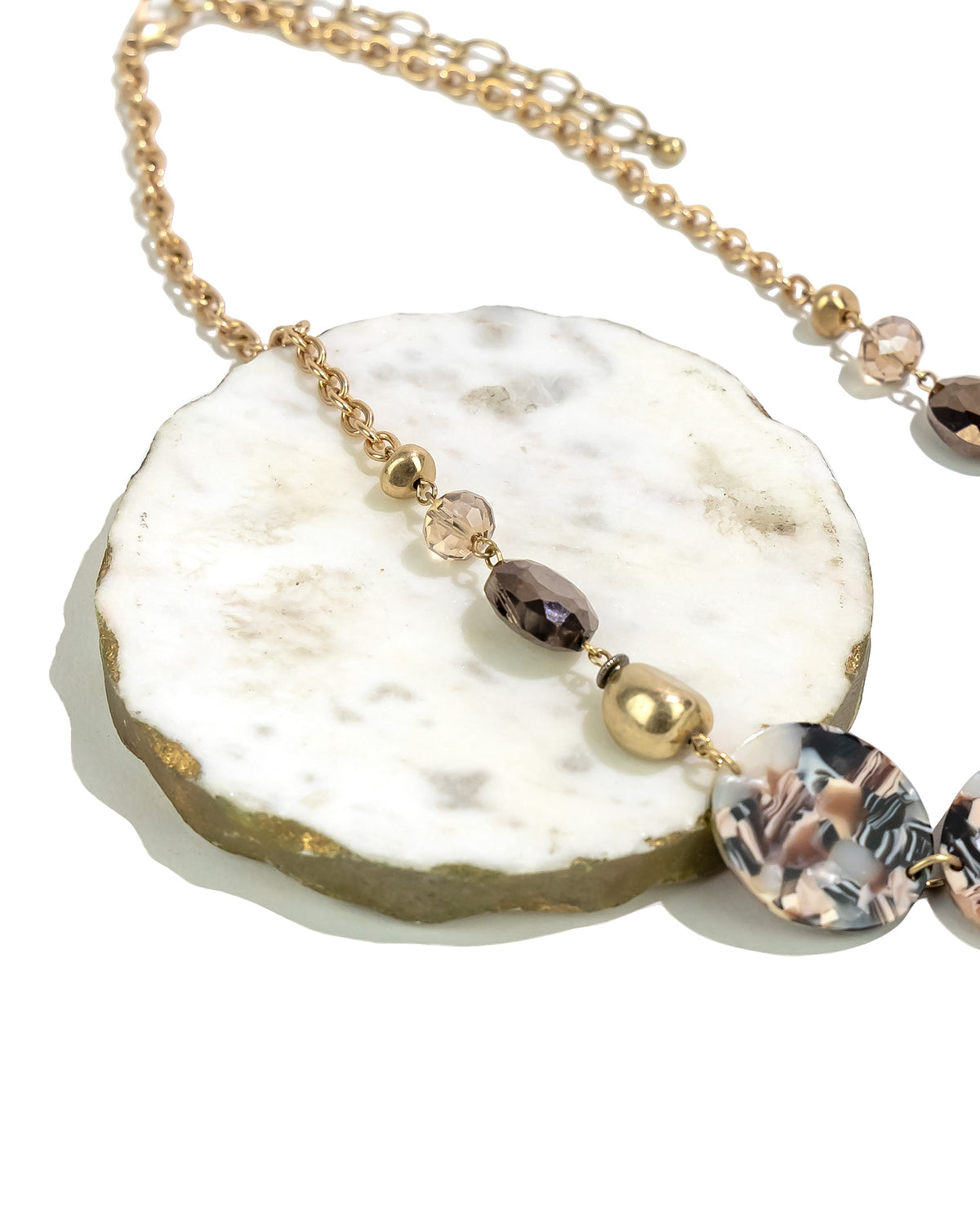 Closeup of Golden Chain Necklace with Marbled Lucite Discs displayed on white background – Dauplaise Jewelry