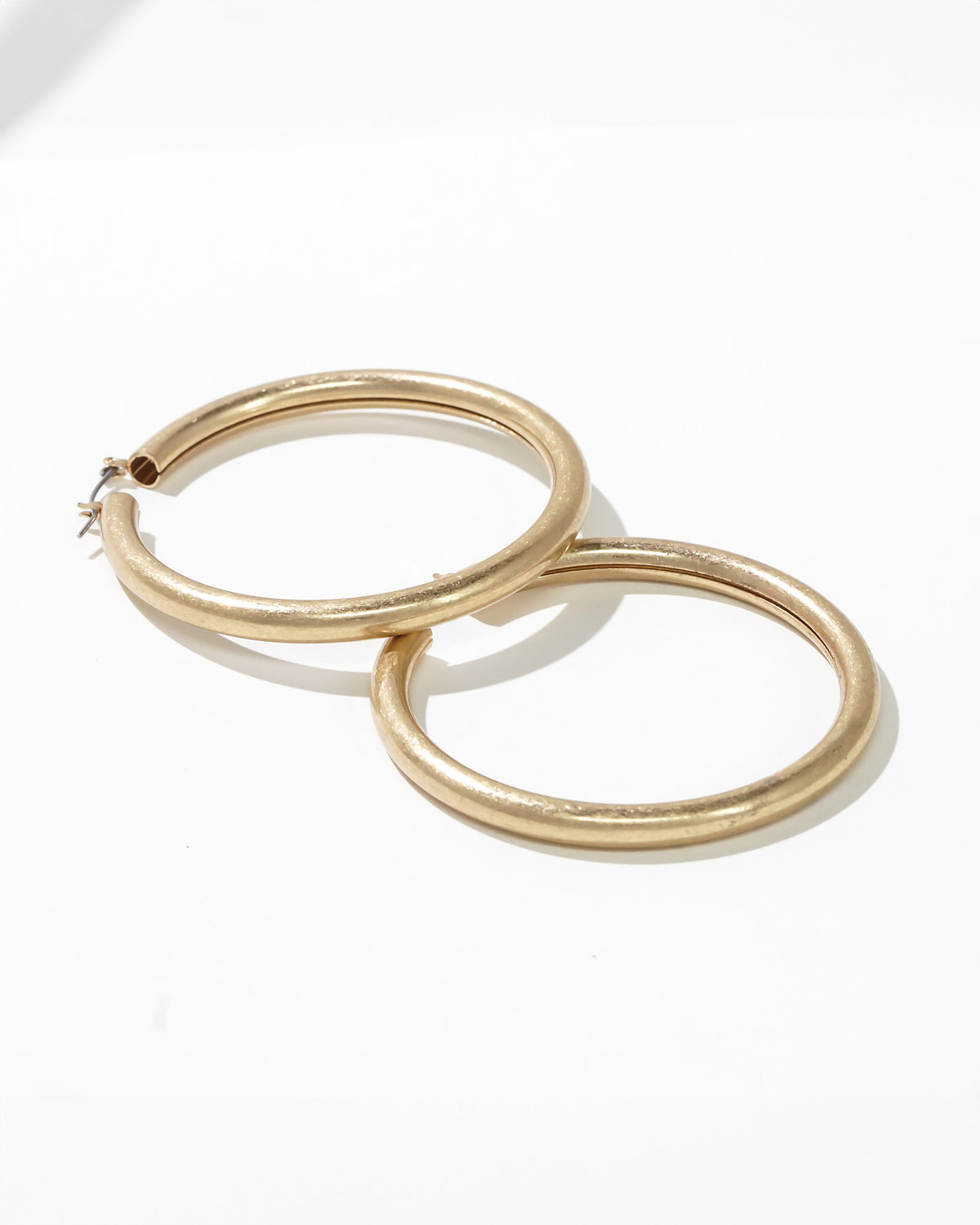 Worn Gold Tubular Hoop Earrings displayed on white background – Dauplaise Jewelry