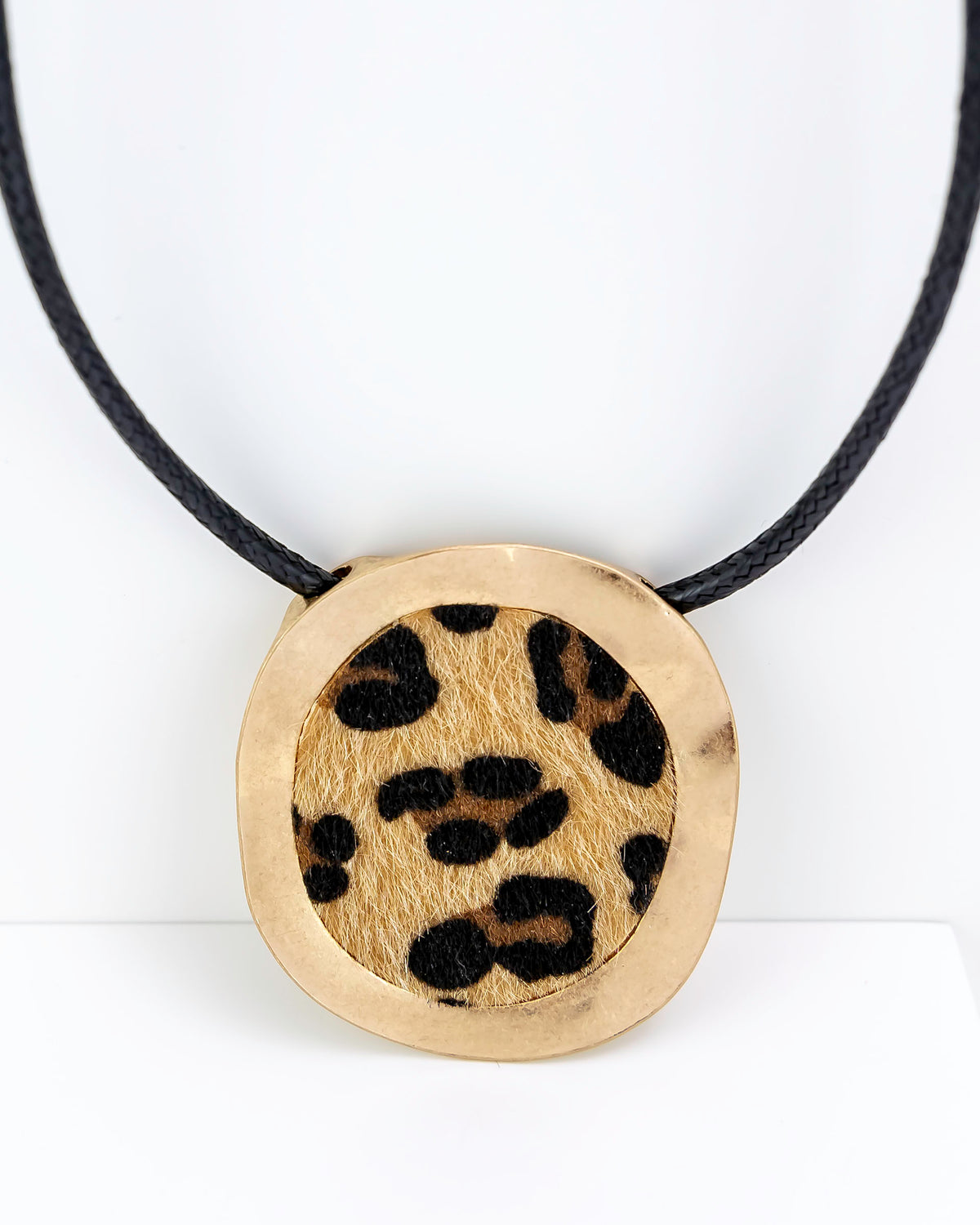 Necklace with a round pendant featuring a leopard print design on a white background