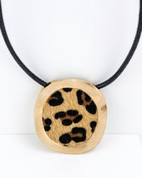 Necklace with a round pendant featuring a leopard print design on a white background