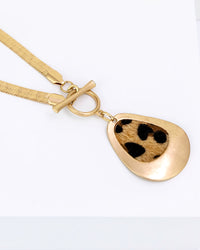 Gold necklace with a teardrop-shaped pendant on a white background
