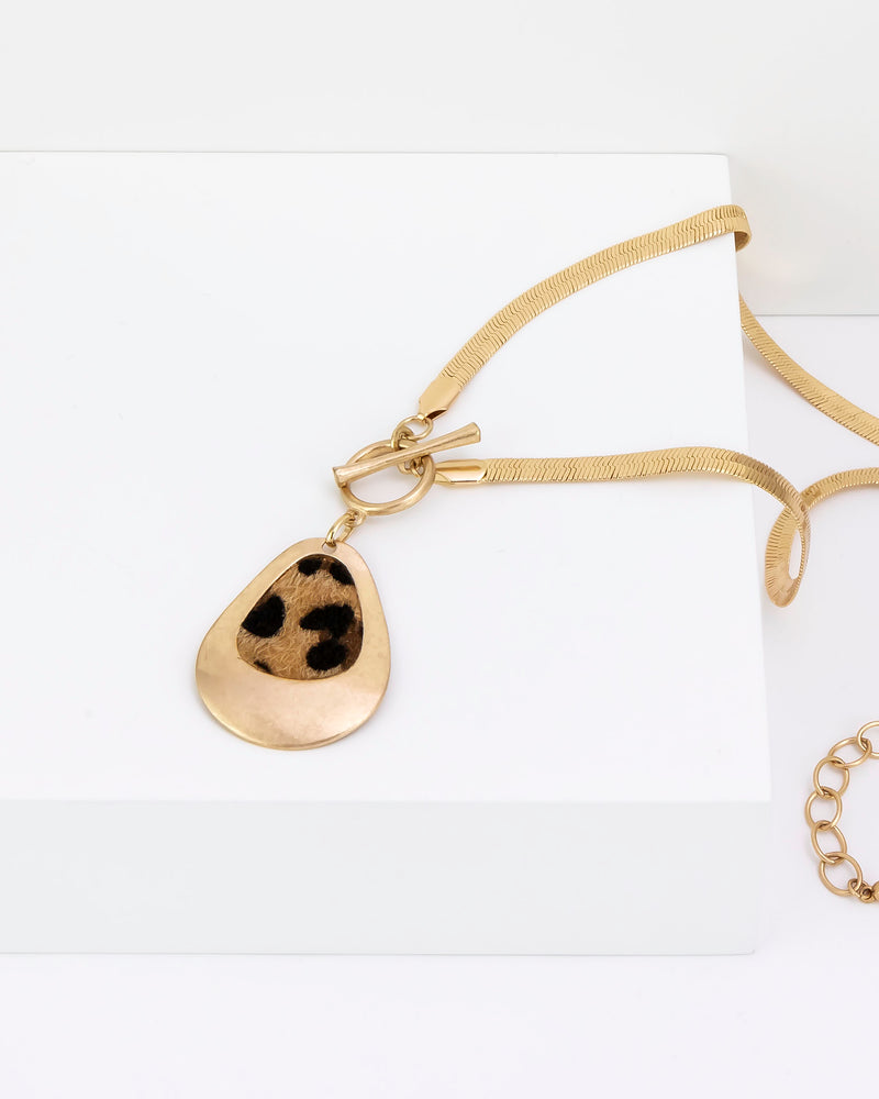 Gold necklace with a teardrop pendant on a white background