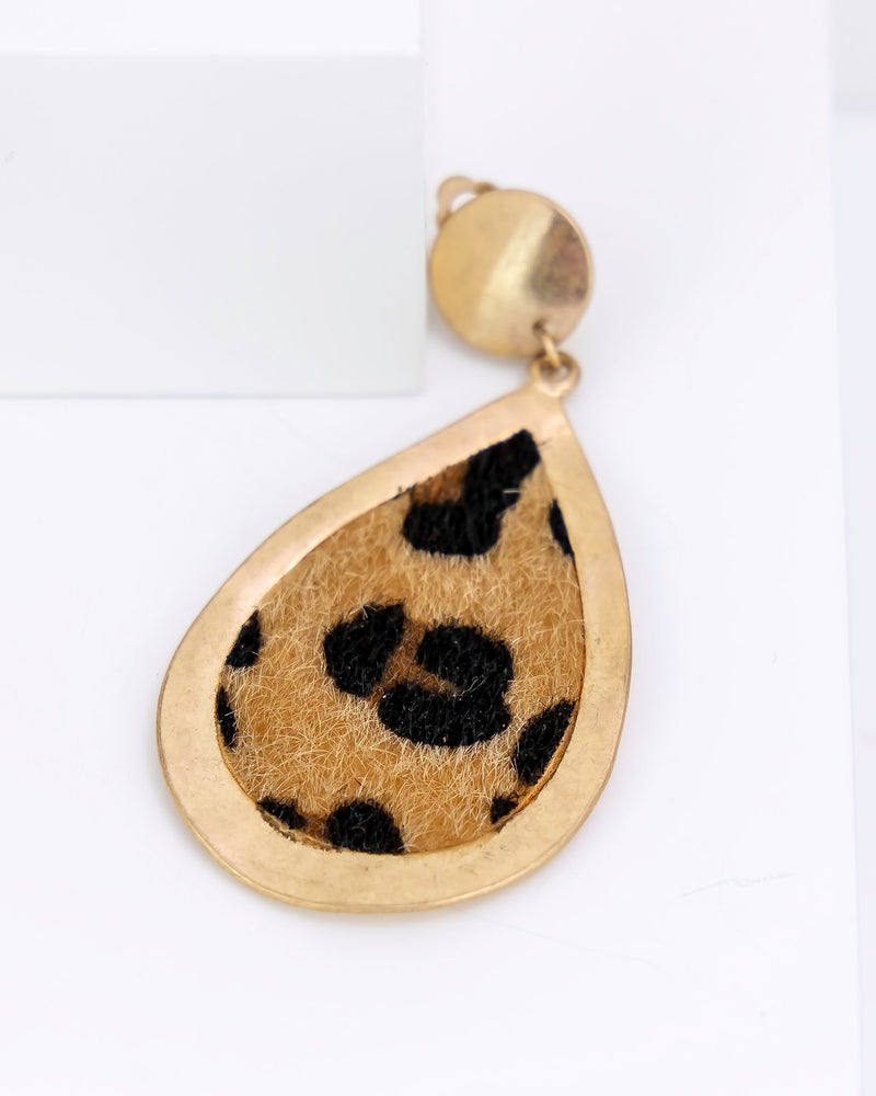 Gold teardrop-shaped pendant with leopard a faux fur print on a white background