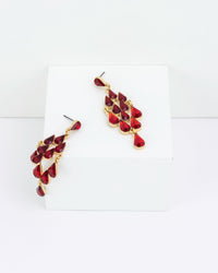 Pair of gold and red chandelier earrings on a white background