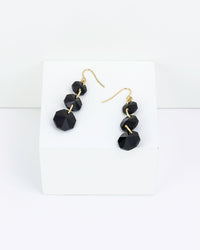 Black faceted three drop earrings on a white background
