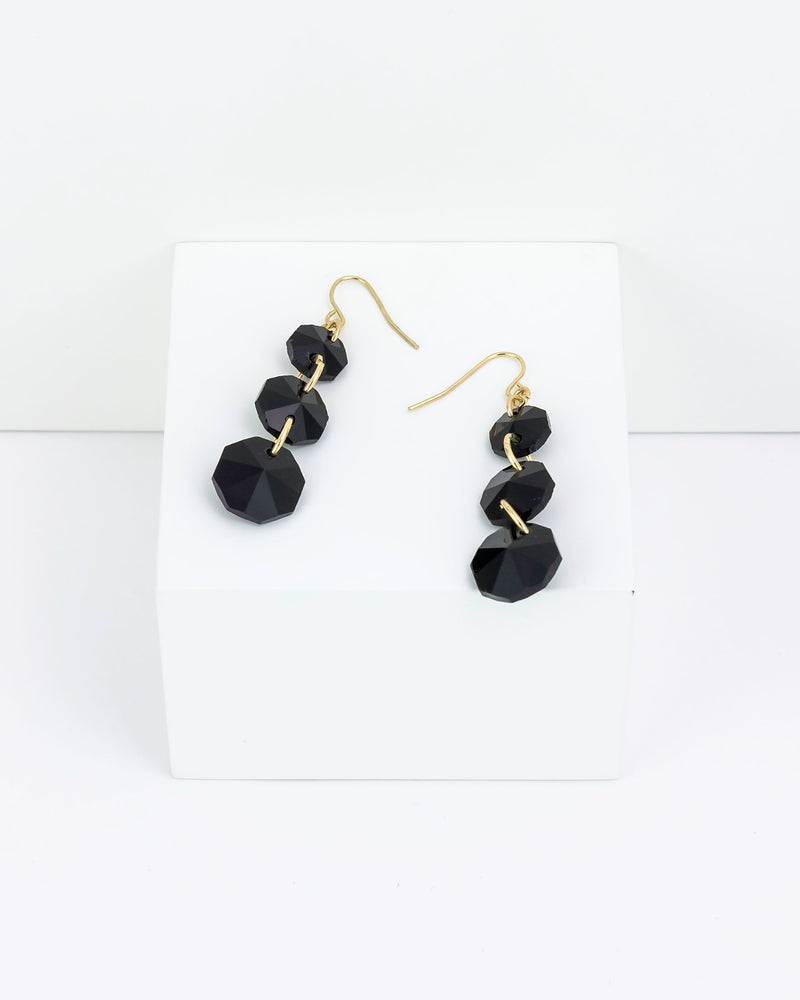 Black faceted three drop earrings on a white background