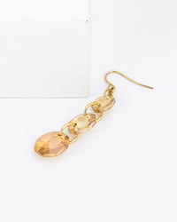 Gold chain earring with faceted gold beads on a white background
