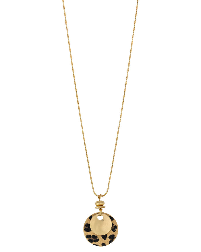 Long worn-gold necklace with layered gold-tone and leopard-print faux calf-hair fabric disc pendant on a white background.