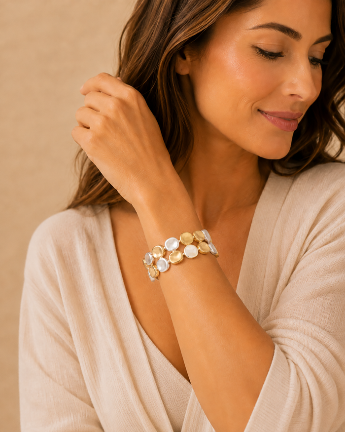 Model wearing a two-row mixed-metal hammered disc stretch bracelet with an ivory blouse.