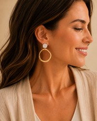 Model wearing two-tone hammered open ring drop earrings with a neutral blouse.