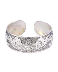 Antique-silver-tone wide open cuff bracelet with an etched floral motif on a white background.