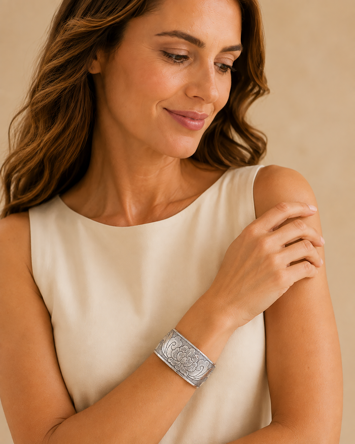 Model wearing an antique-silver-tone etched floral wide cuff bracelet with an ivory dress.