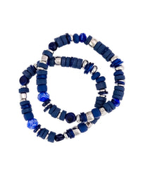 Blue two-row stretch bracelet with mixed bead shapes and worn-silver-tone accents on a white background.