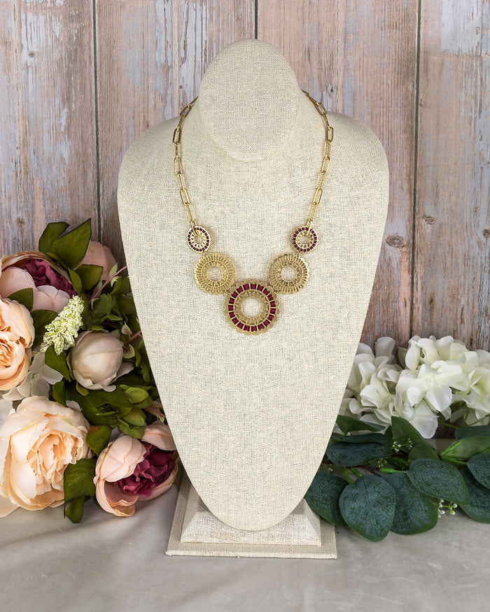 Necklace on a mannequin bust with flowers in the background