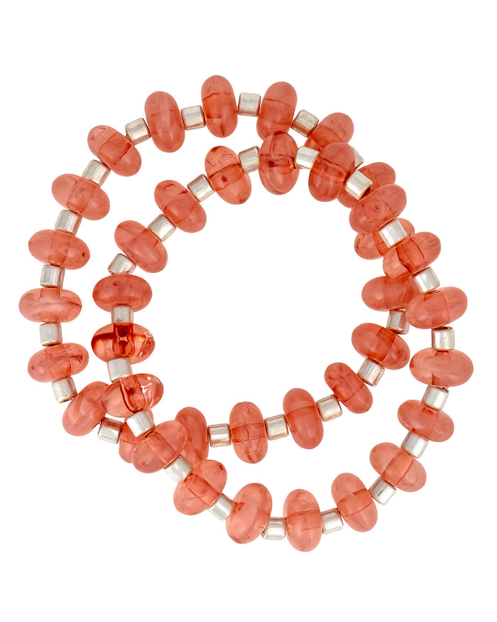 Beaded bracelet with coral-colored beads on a white background