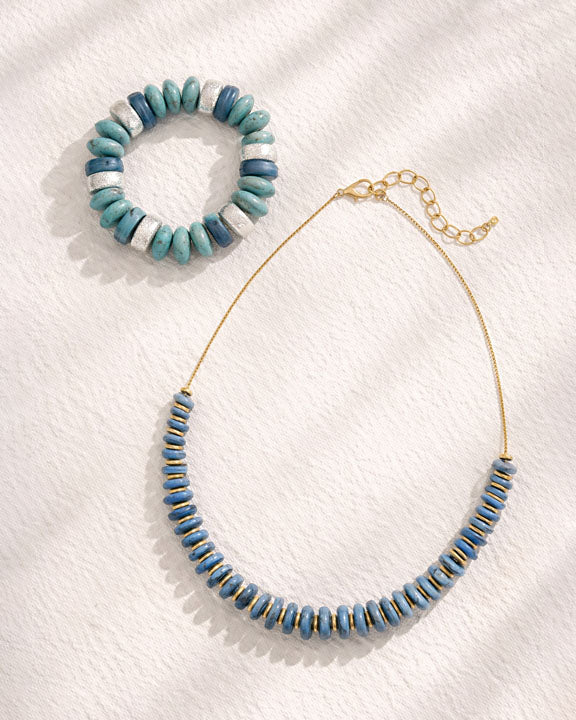 Necklace and bracelet with blue and white beads on a white background