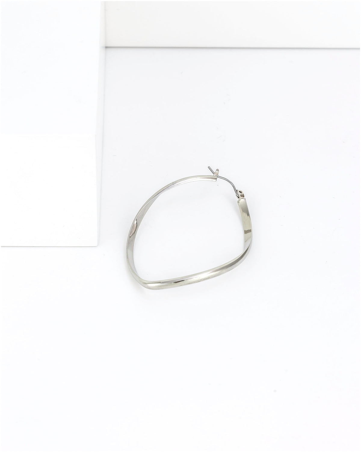 Silver hoop earring on a white background