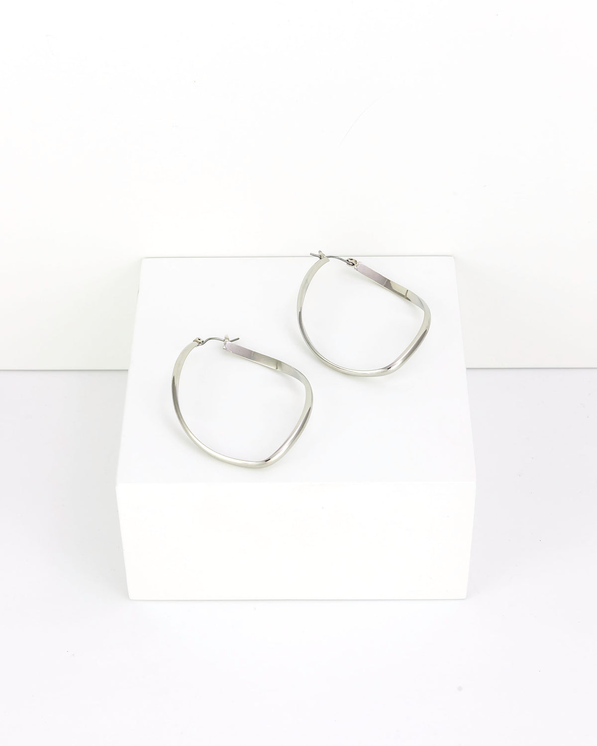 Pair of silver hoop earrings on a white background