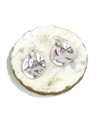 Silver earrings on a white marble surface