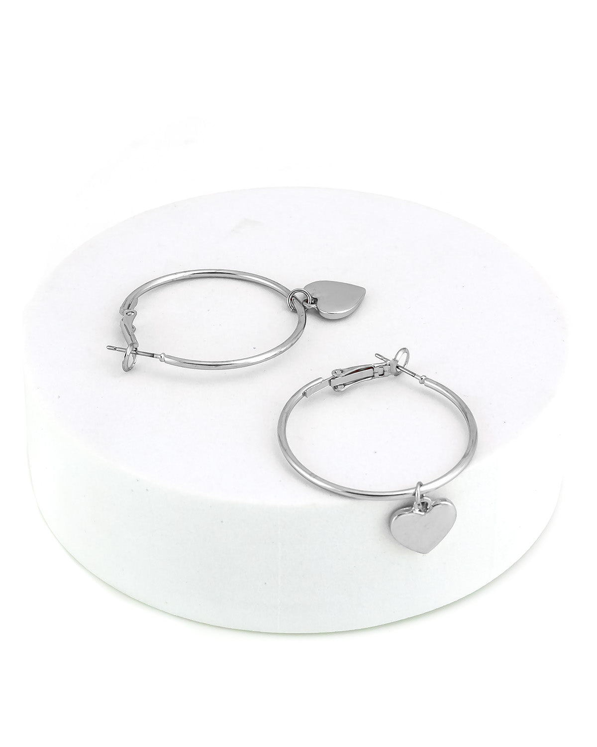 Silver hoop earrings with heart charms on a white background