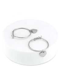 Silver hoop earrings with heart charms on a white background
