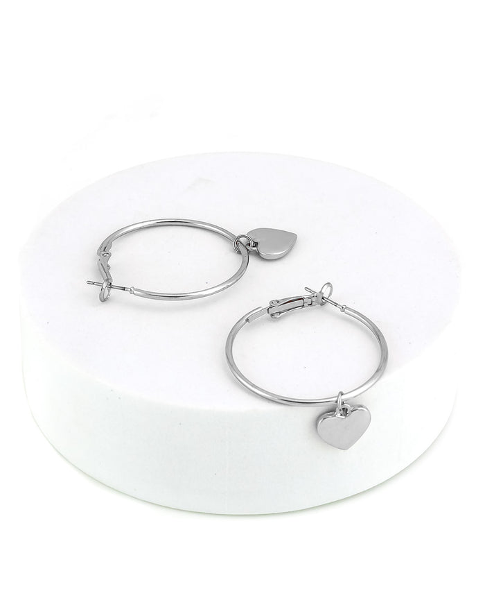 Silver hoop earrings with heart charms on a white background