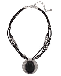 Black multi-strand cord necklace with beads and an oval black cabochon in an antique-silver-tone frame on a white background.